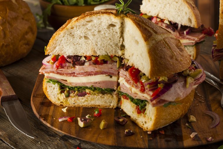 new-orleans style muffuletta sandwich with kentucky legend ham, salami, turkey and olive spread